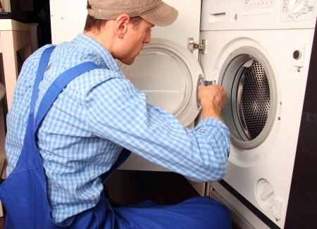 technician repairing a dryer