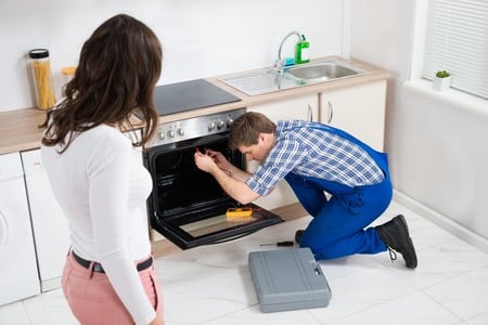 repairman fixing the oven