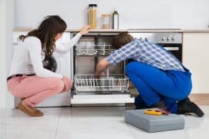 repair man fixing dishwasher