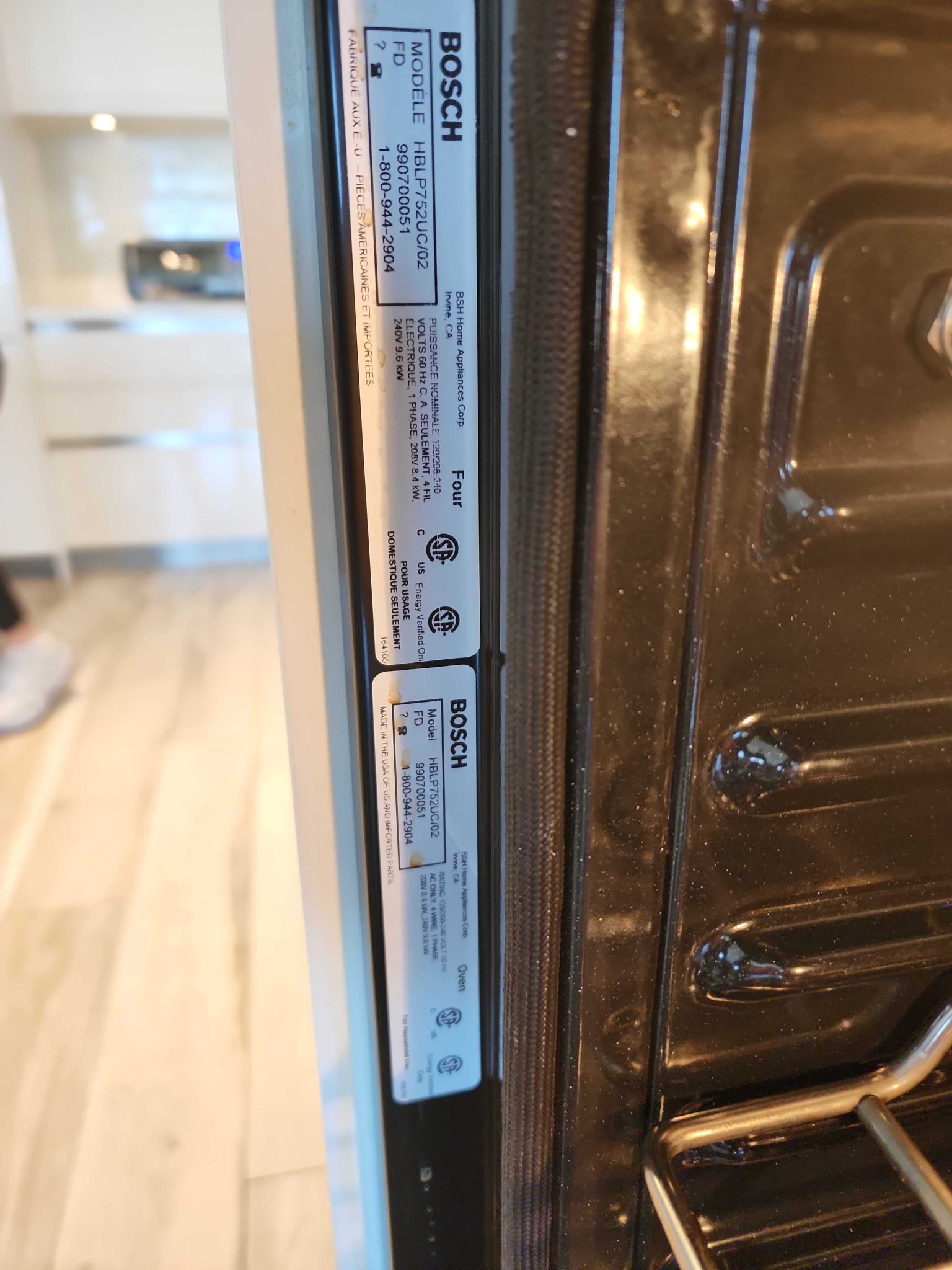 Manufacturer specification sticker located inside the door frame of a Bosch built-in microwave, displaying the model number HBLP752UC/02.