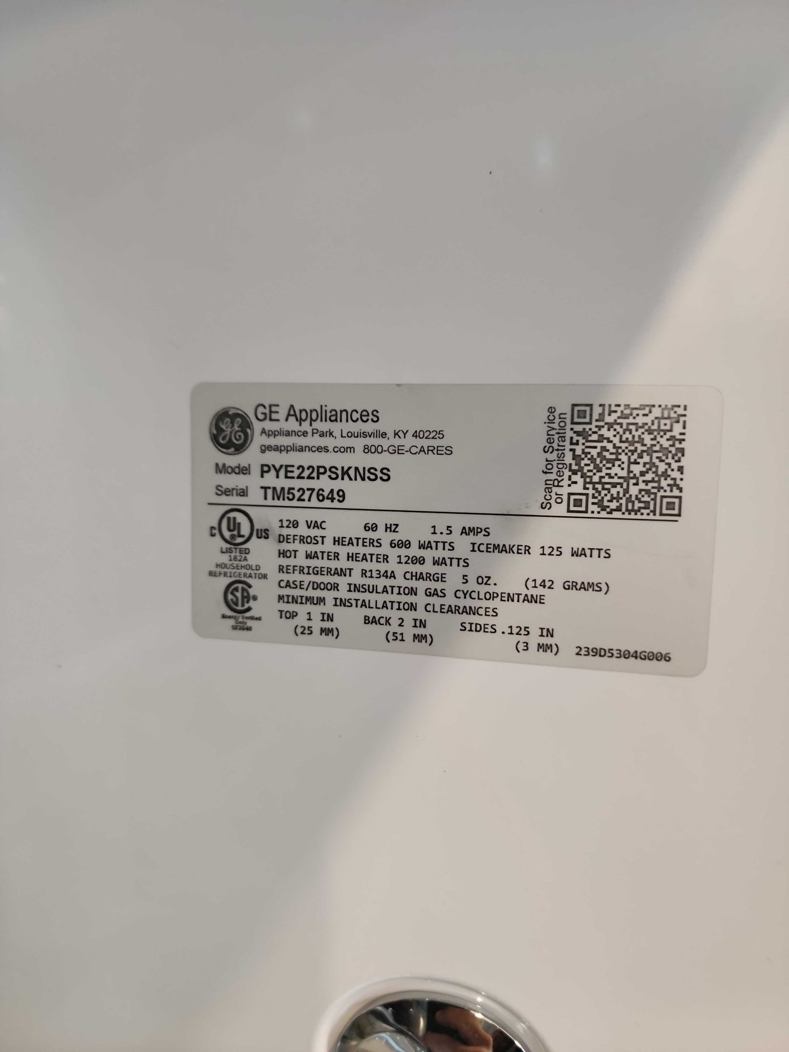 A manufacturer specification sticker on a white GE refrigerator interior wall showing model number PYE22PSKNSS and serial number TM527649.