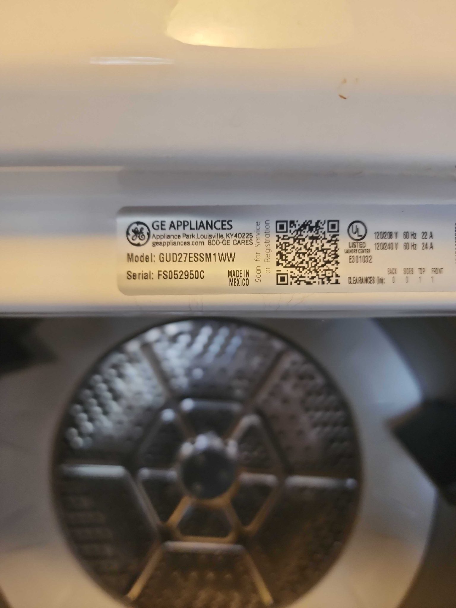 Manufacturer specification sticker for a GE Stacked Laundry Center showing model number GUD27ESSM1WW and serial number FS052950C.