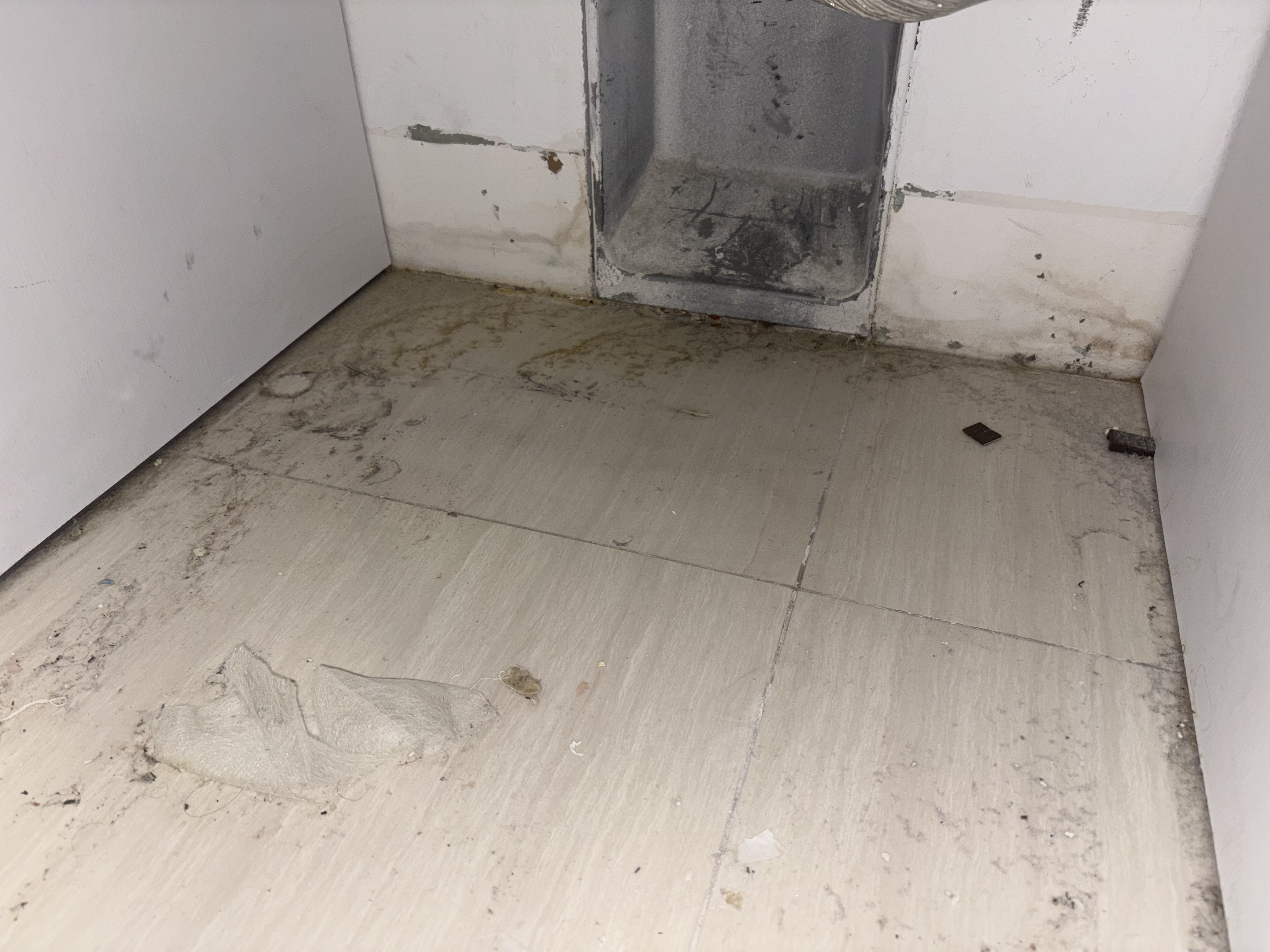 Inspection of the floor behind a GE washing machine in Boca Raton FL RR0065, showing no active leak.