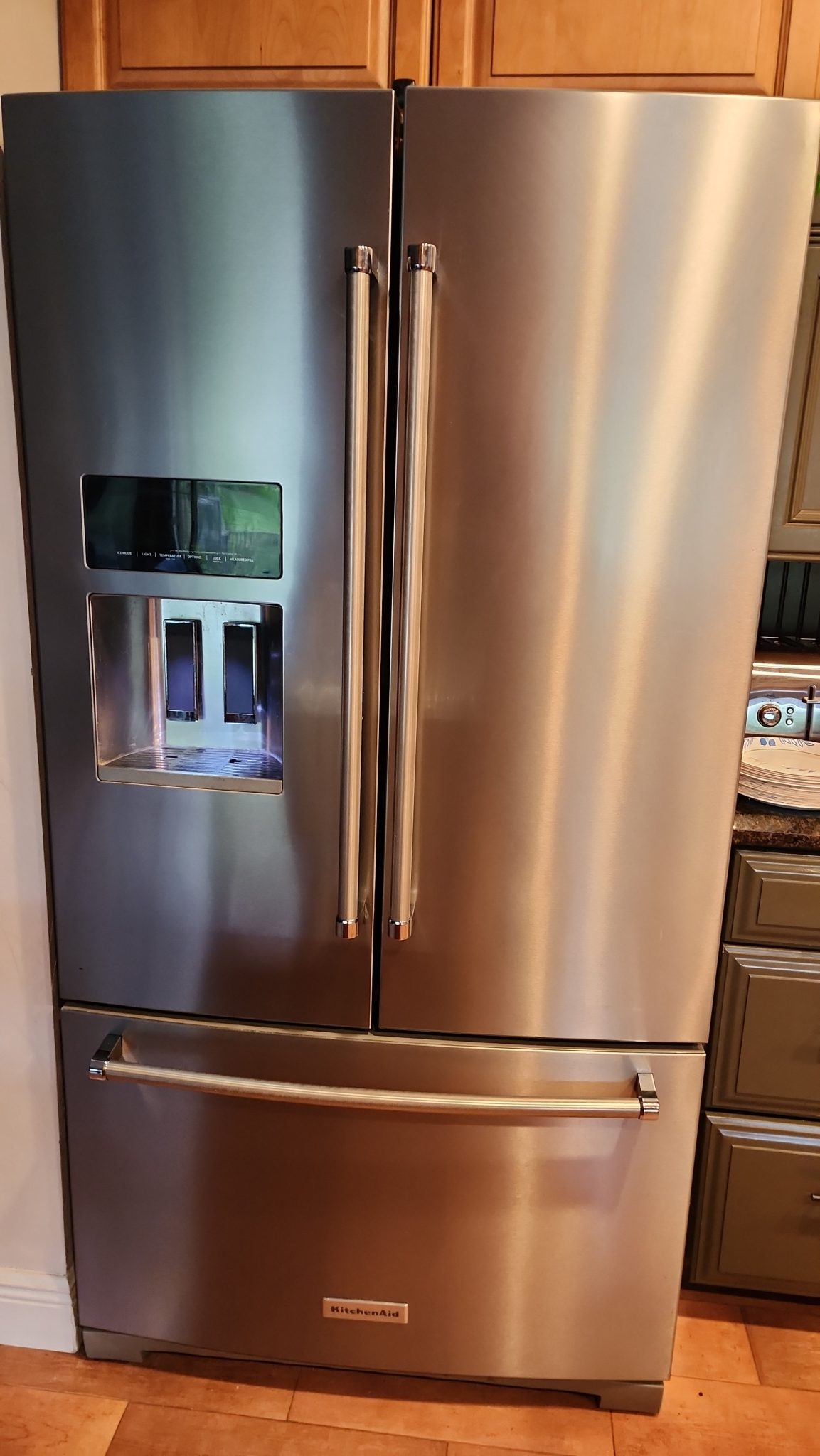 Stainless steel KitchenAid French door refrigerator (Model KRFF507HPS00) with exterior ice and water dispenser situated in a customer's kitchen in Coral Springs, FL prior to repair.