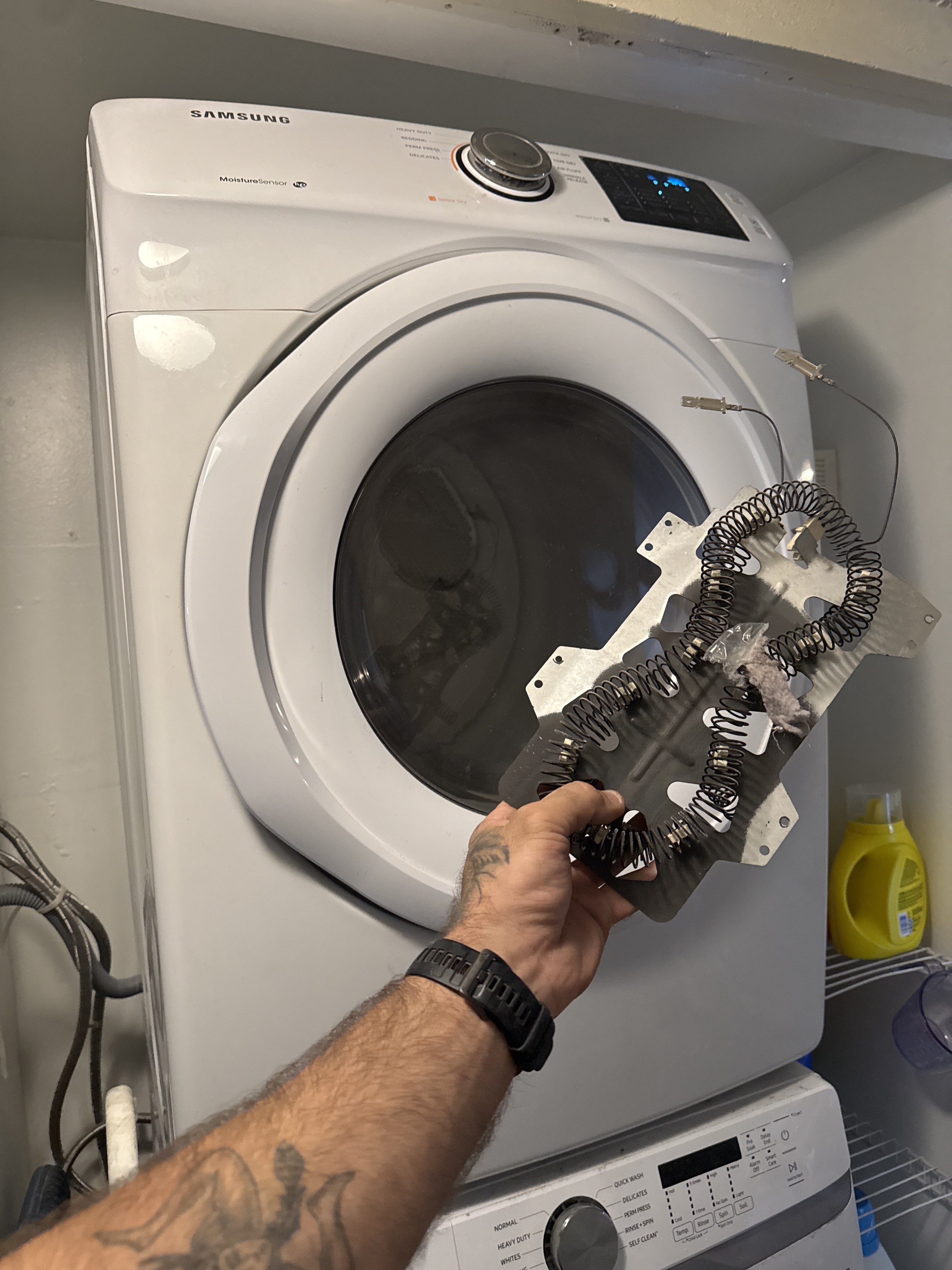 Technician holding failed heating element during Samsung dryer repair in Coral Springs FL RR0077