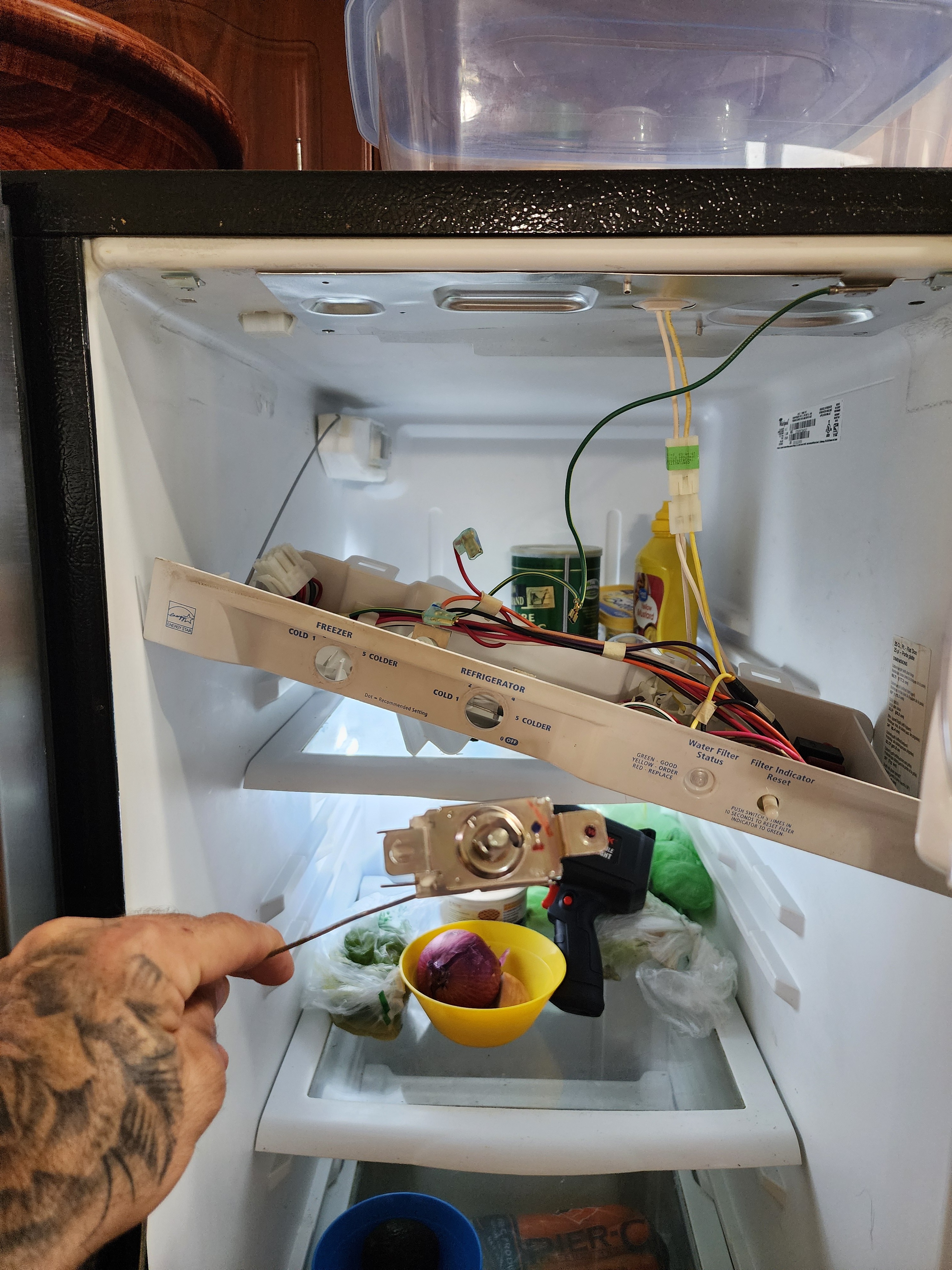 Technician replacing the defective cold control thermostat assembly in a Whirlpool refrigerator RR0102