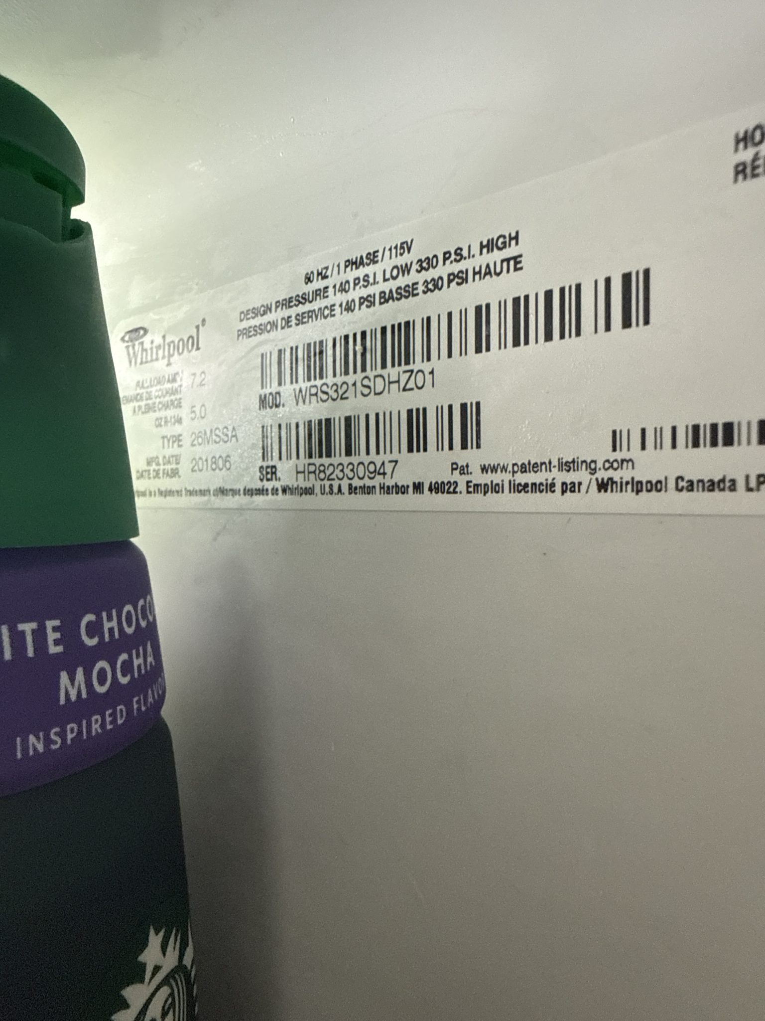 Close-up view of the interior manufacturer sticker on a Whirlpool refrigerator, displaying model number WRS321SDHZ01.